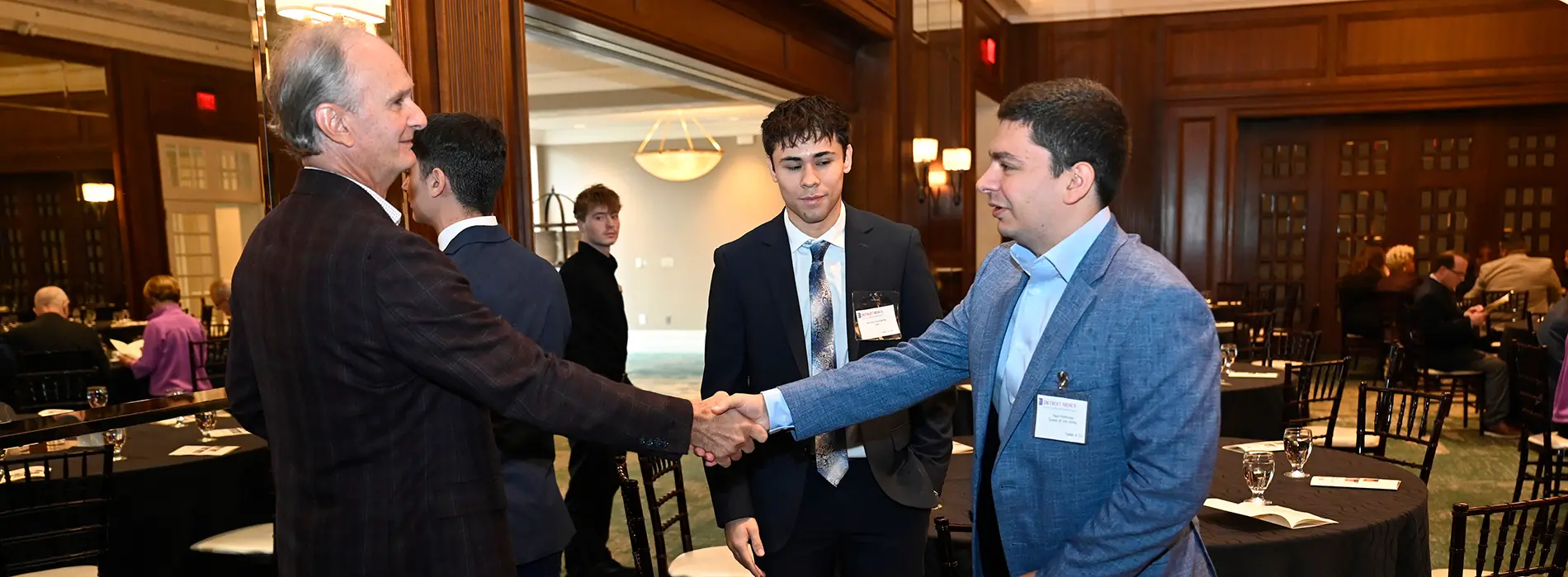 student and alumni shaking hands