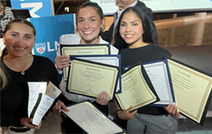 Angela Yuhana, Alexa Prenkocevic, and Ivy Miah hold up certificates in a selfie.